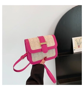 Détail de la garniture en cuir fuchsia et de la paille tressée du sac à bandoulière