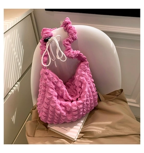 Detail of pink popcorn textured shoulder bag with scrunchie strap and white drawstring