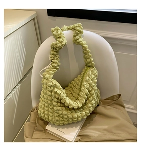 Detail of light green bubble texture on a pleated shoulder bag for women with zipper closure