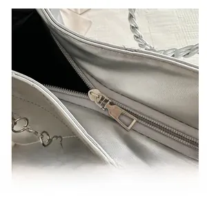 Close-up of smooth silver metal zipper and quilted texture on a large capacity tote bag