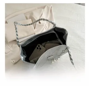 Interior view of silver quilted tote bag showing large capacity for phone and wallet
