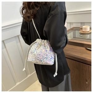 Detail shot of a mini sequin drawstring bucket bag with iridescent finish and rope strap