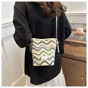 Detail of the colorful wavy knit pattern and fashion tag on the woven bucket bag