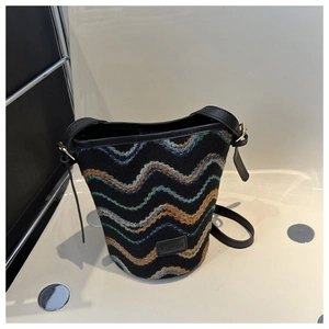 Detail of multi-color wavy knit fabric bucket bag with black leather fashion tag