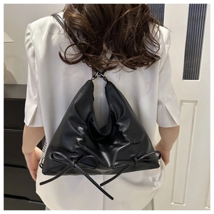 Détail du sac à bandoulière triangulaire en cuir PU noir avec nœuds décoratifs et chaîne