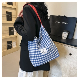 Sac fourre-tout à carreaux bleus et blancs avec bandoulière rouge en scène de vie
