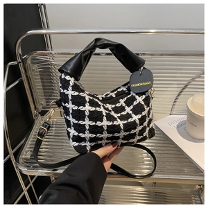 Détail du sac en tweed à carreaux avec poignées en cuir et fermetures en métal doré