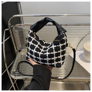 Gros plan sur le sac à main en tweed à carreaux noir et blanc avec boucles dorées