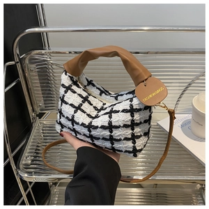 Détail du sac à main tissé à carreaux avec poignée en cuir marron et bandoulière réglable