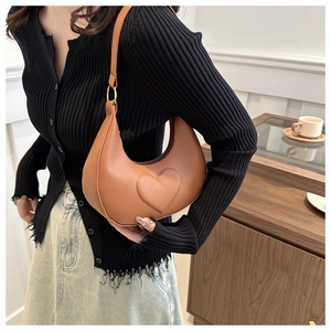 Detailaufnahme der braunen PU-Leder Handtasche mit Herzprägung und goldfarbenen Ringen