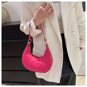 Détail du sac hobo rose vif avec motif coeur gaufré et texture en cuir élégante pour femmes
