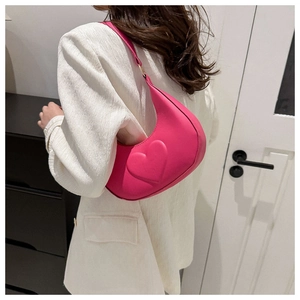 Gros plan d'un sac demi-lune rose vif avec un grand décor en forme de cœur en 3D