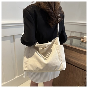 Détail d'un sac cabas en velours côtelé beige avec poche latérale et texture douce