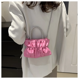 Pink pleated crossbody bag with a sparkling rhinestone handle and silver chain strap