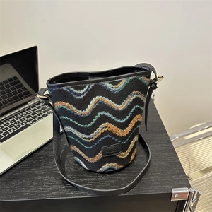 Retro black bucket bag with multi-color wave embroidery on a textured canvas base