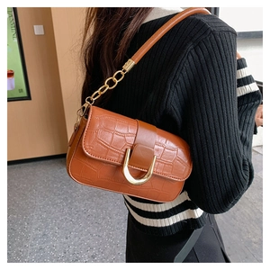 Détail du sac bandoulière orange à motif crocodile avec boucle en U dorée