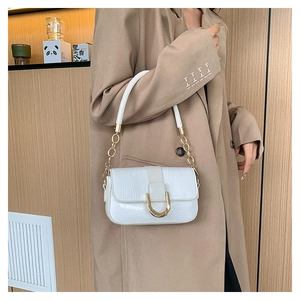 Détail du sac blanc effet crocodile avec boucle dorée et bandoulière en chaîne métal