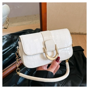 Détail du sac blanc à texture crocodile avec fermoir métallique en forme de U doré