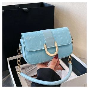 Détail du sac à main bleu clair en similicuir crocodile avec boucle dorée en fer à cheval