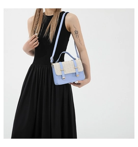 Detail of blue leather and beige woven texture on a stylish women's crossbody handbag