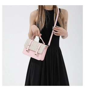 Detail of pink leather and beige straw patchwork crossbody bag with metal hardware