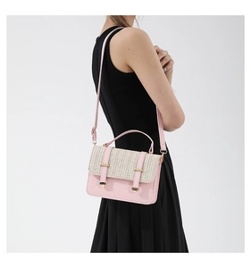 Detail of pink PU leather and straw woven crossbody bag with gold metal buckle