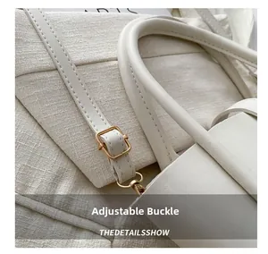 Close-up of golden adjustable buckle and stitching on the white leather tote bag