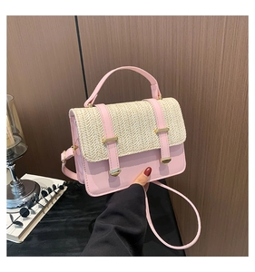 Close-up of pink straw woven handbag featuring gold metal buckle and leather strap