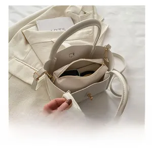 Detail view of cream PU leather bucket bag with gold clasp and removable inner pouch