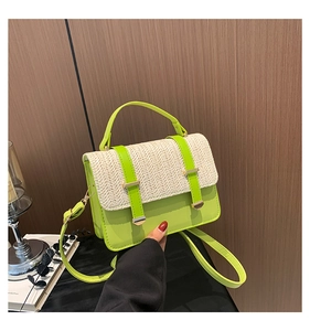 Detail view of neon green crossbody bag with textured beige woven flap and gold hardware