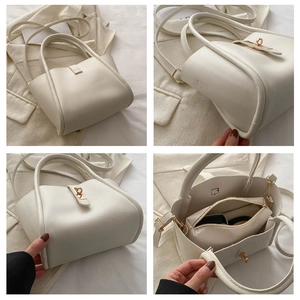 Detail view of white leather tote bag featuring metal lock and internal zipper pouch