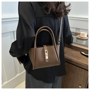 Brown structured tote bag shown in a lifestyle setting on a model's shoulder