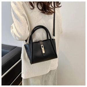 Detail view of the black tote bag with gold hardware and removable shoulder strap