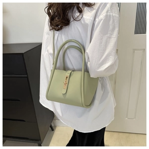 Detail of sage green matte leather tote bag with gold metallic twist lock and slim strap