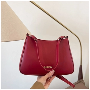 Dettaglio borsa in pelle lucida rossa con logo JINGPIN in metallo dorato e finitura