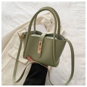 Detail view of the green crossbody tote bag with golden metal clasp and vegan leather texture