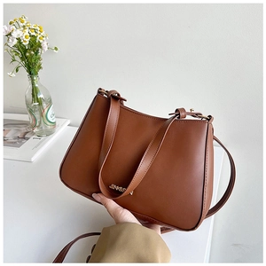 Dettaglio della borsa in pelle PU caramello con logo JINGPIN in metallo dorato e design