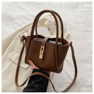 Detail of dark brown leather tote showing gold metal clasp and interior zipper pouch