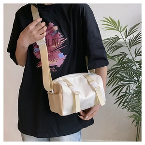 Detail of minimalist contrast crossbody bag with buckle straps and adjustable strap