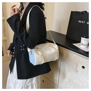 Fashionable blue and white cylinder crossbody bag shown on model for a trendy commute look