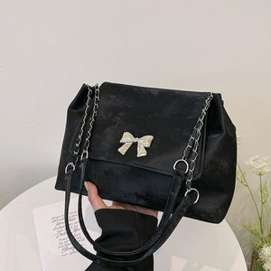 Elegant black velvet bucket bag with a silver bow and metal chain strap for women