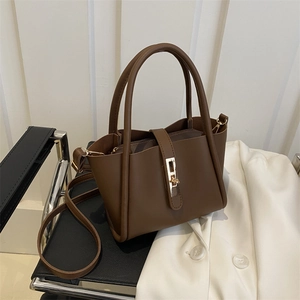 Minimalist dark brown leather tote bag with gold metal buckle and shoulder strap for office