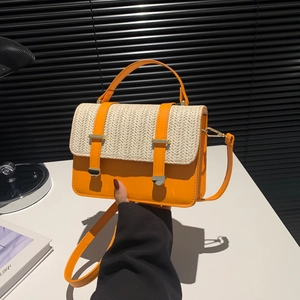 Fashionable straw woven handbag in bright orange with leather flap and gold metal buckles