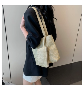 Detail of woven straw tote bag set featuring main shoulder bag and matching small pouch
