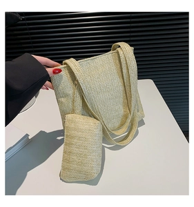 Detail view of woven straw tote bag with matching zippered pouch in natural beige color