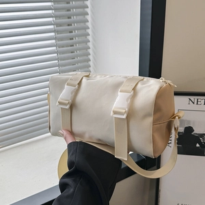 Minimalist beige cylindrical crossbody bag with functional buckles and adjustable straps