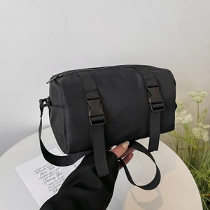 Minimalist black cylinder shoulder bag in nylon for women with buckle details