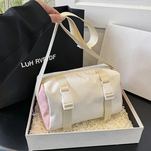 Fashionable cylinder crossbody bag in cream and pink, shown in a premium gift box presentation