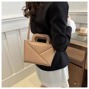 Detail view of khaki crossbody bag with 3D geometric folds and fashion logo print