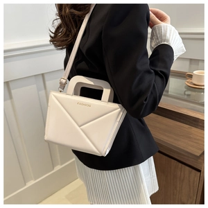 Detail of white geometric crossbody bag with textured triangular panels and gold lettering